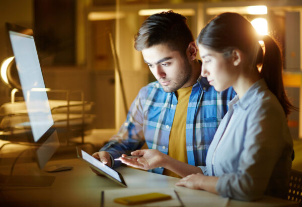 Concentrated specialists looking through online ideas or projects while preparing their own one